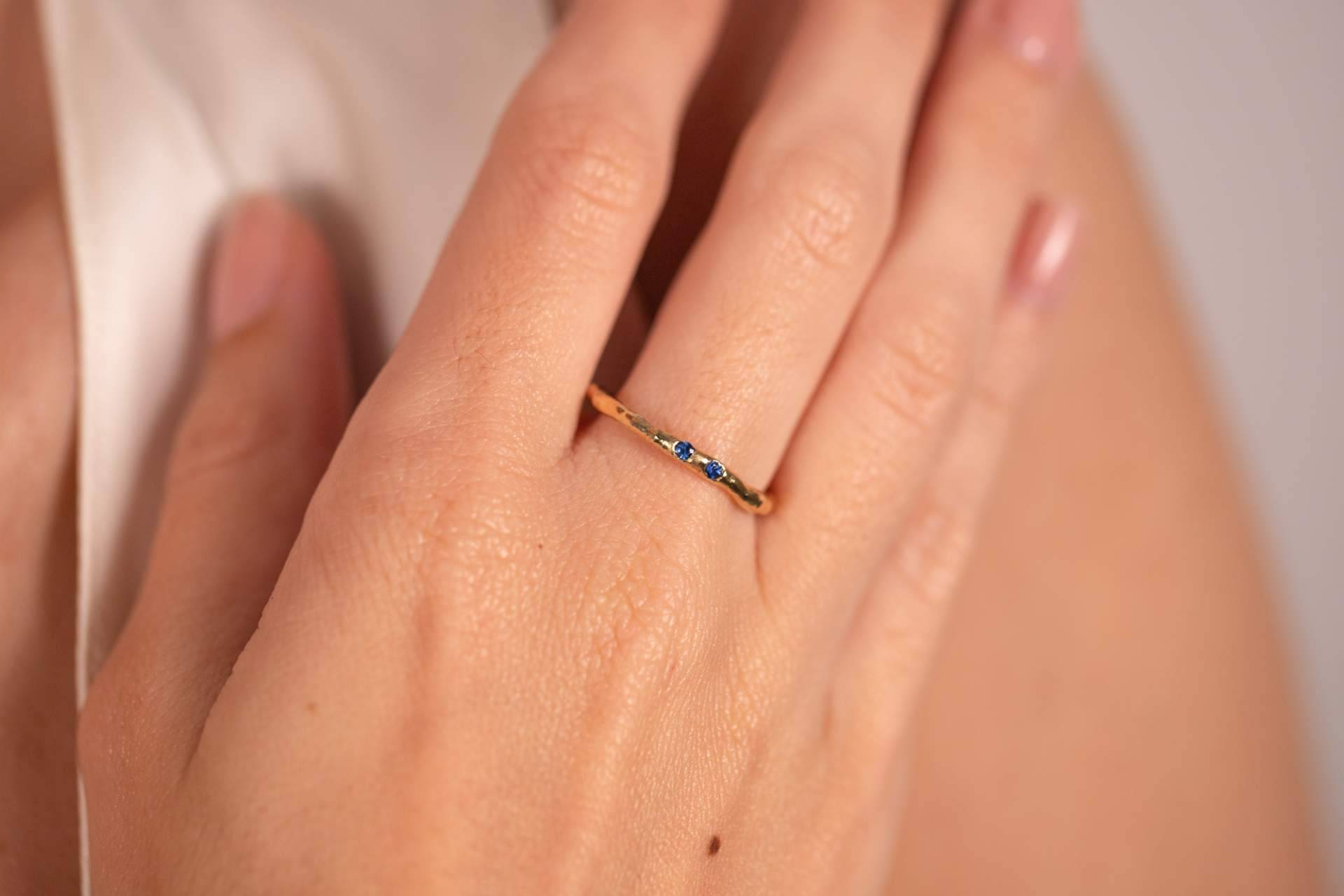 Elegancia cromática en la mano; anillo con esmeralda y anillos con zafiros